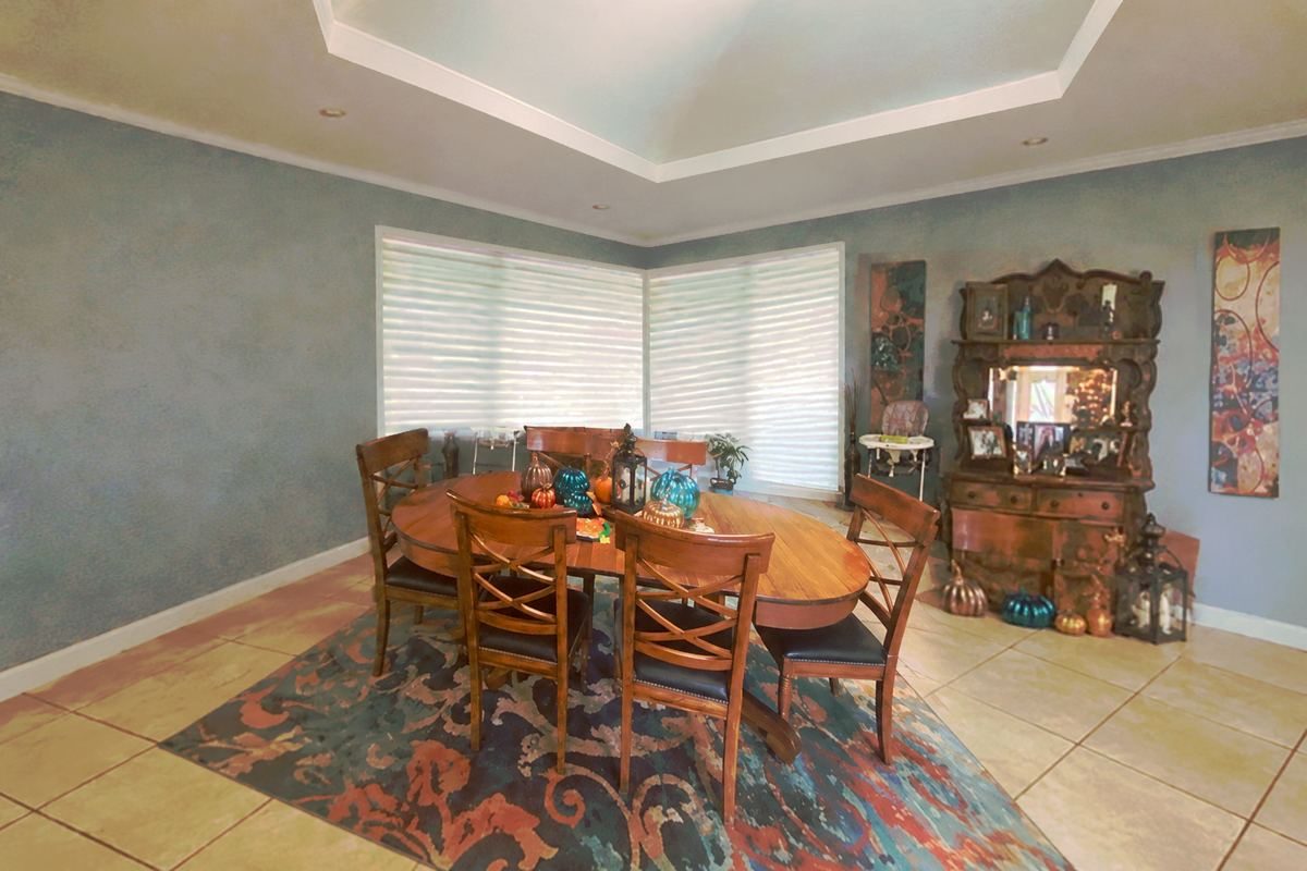 The dining room before: tile floors, pale blue walls and a dated layout