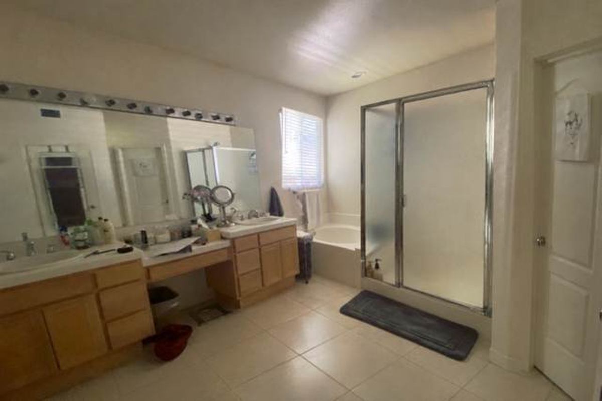 The bathroom before: an oak vanity, a corner tub and a framed shower