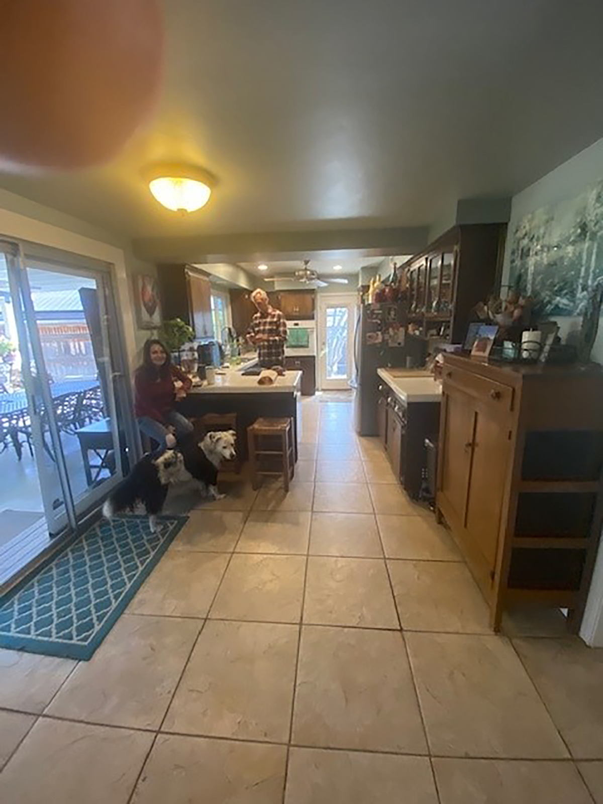 The same kitchen before: a narrow, dim galley with tile floors