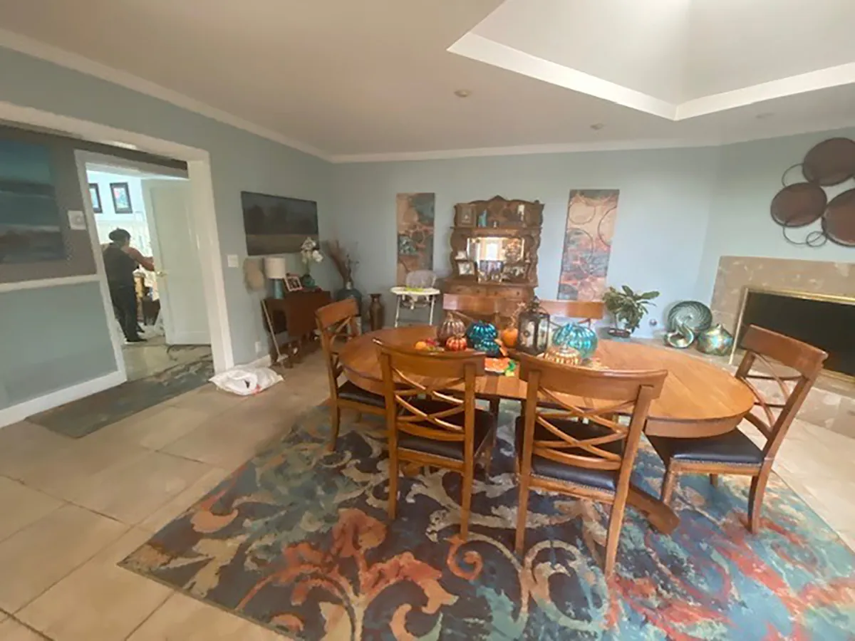 The dining room before: tile floors, pale blue walls and a dated layout