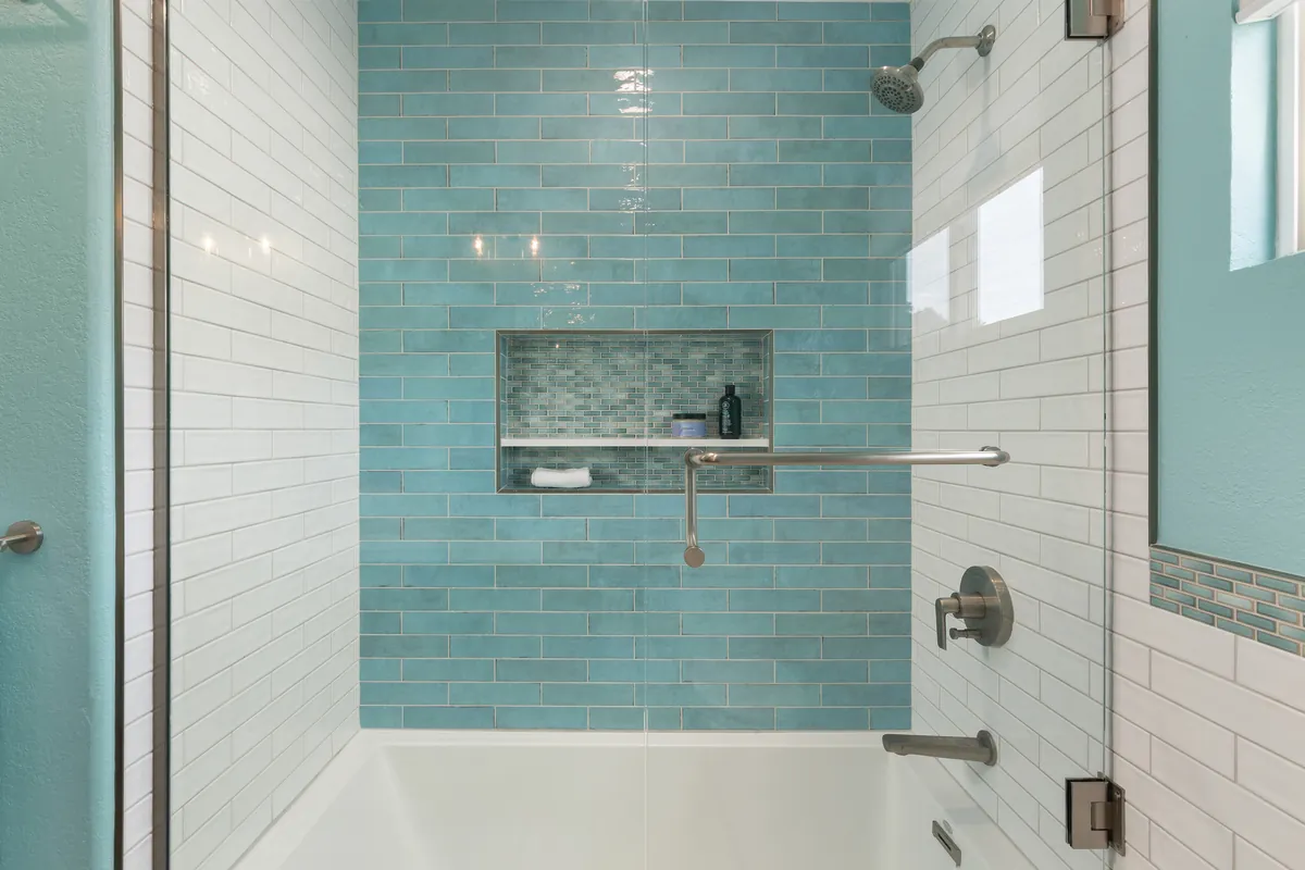 Bathroom with aqua tile, a white subway tile surround and a built-in niche